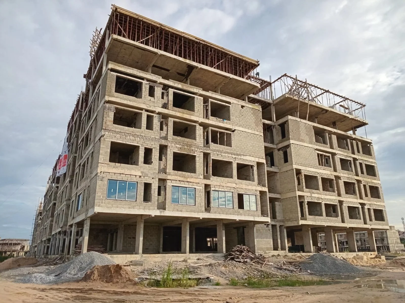 The Toll Heights apartment blocks at roof-slab stage under an evening sky